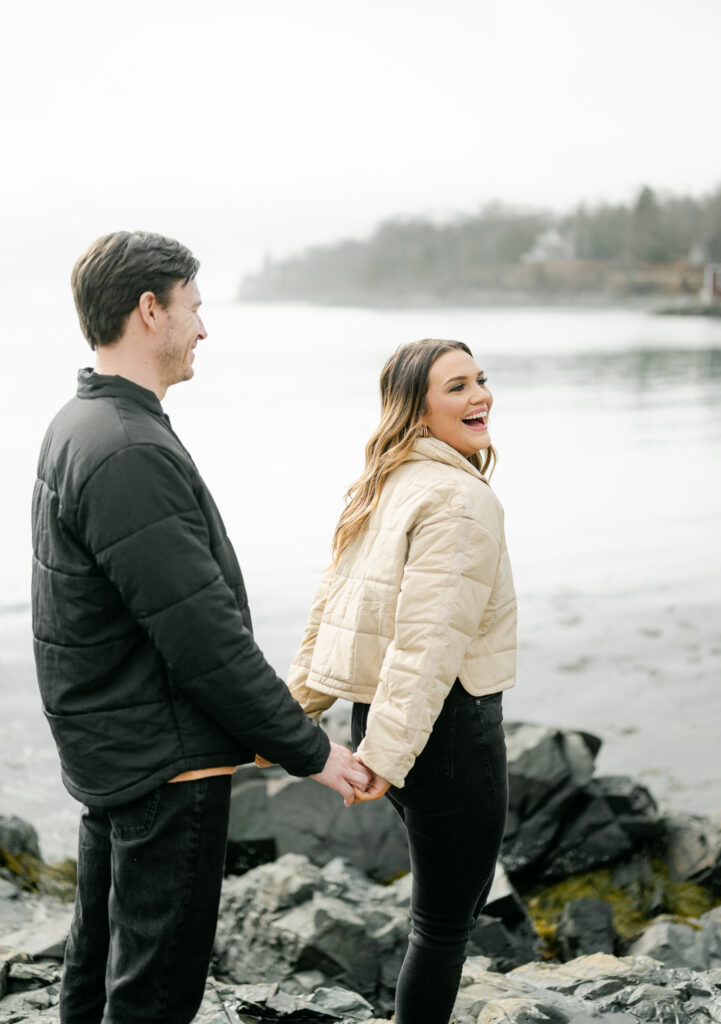 engagement session coastal rocky beach maine couple laughing