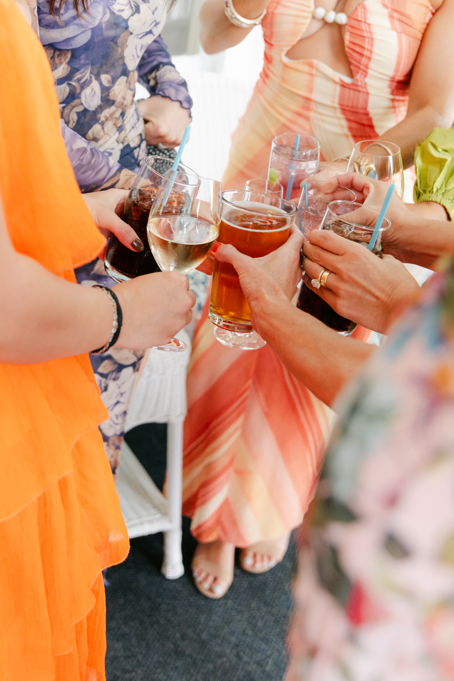 Colorful guest dress code ideas featuring vibrant orange and red attire that complement citrus florals at a joyful Maine wedding.