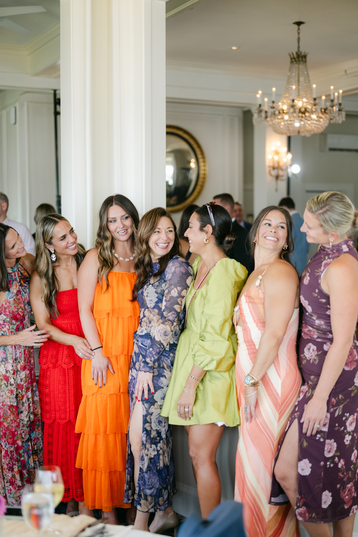 guests at a wedding wearing bright red, orange, chartreuse, peach, purple and blue