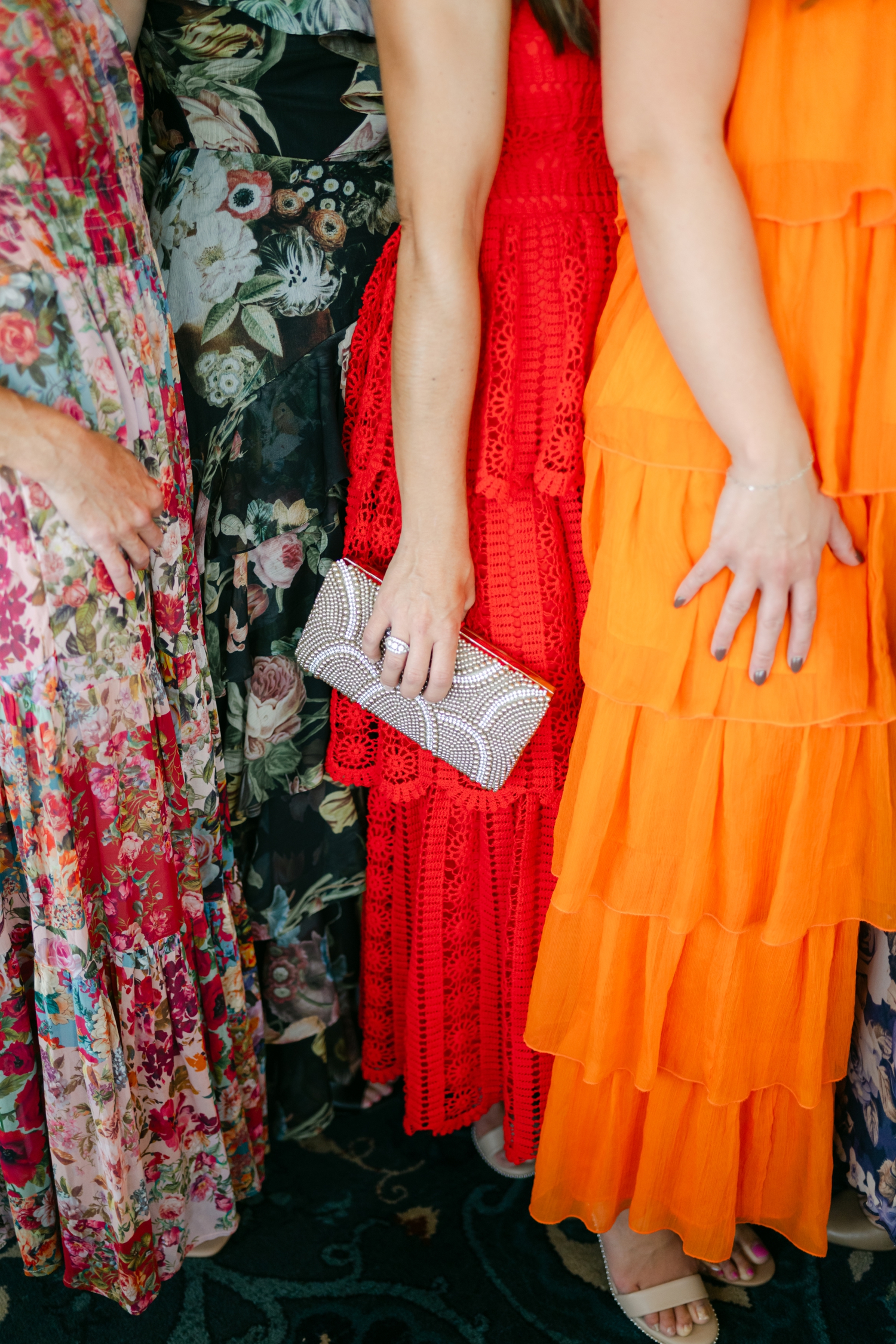 Colorful guest dress code ideas featuring vibrant orange and red attire that complement citrus florals at a joyful Maine wedding.