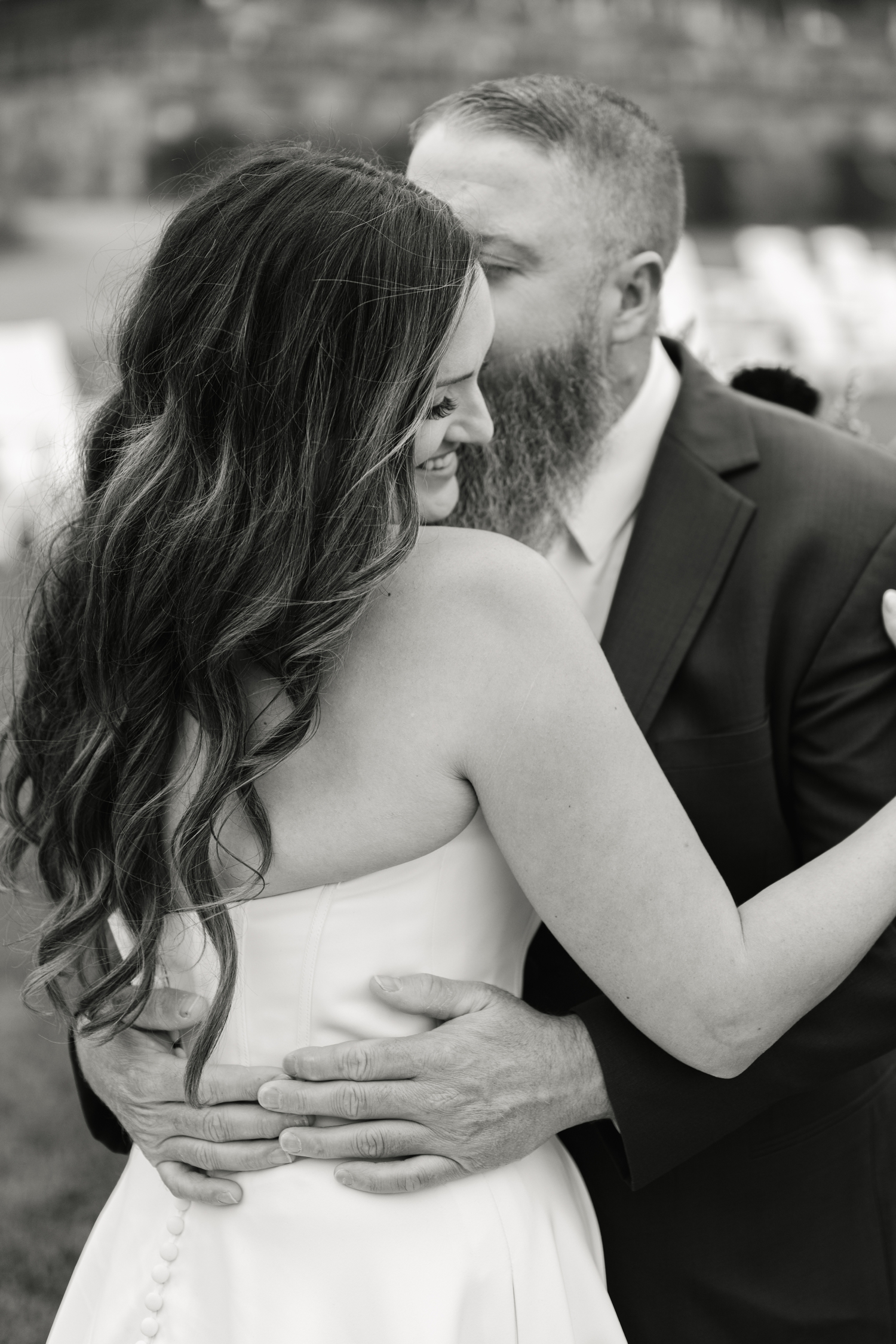 Bride and Groom standing outside the Asticou Inn during their autumn micro-wedding with soft foliage behind them.