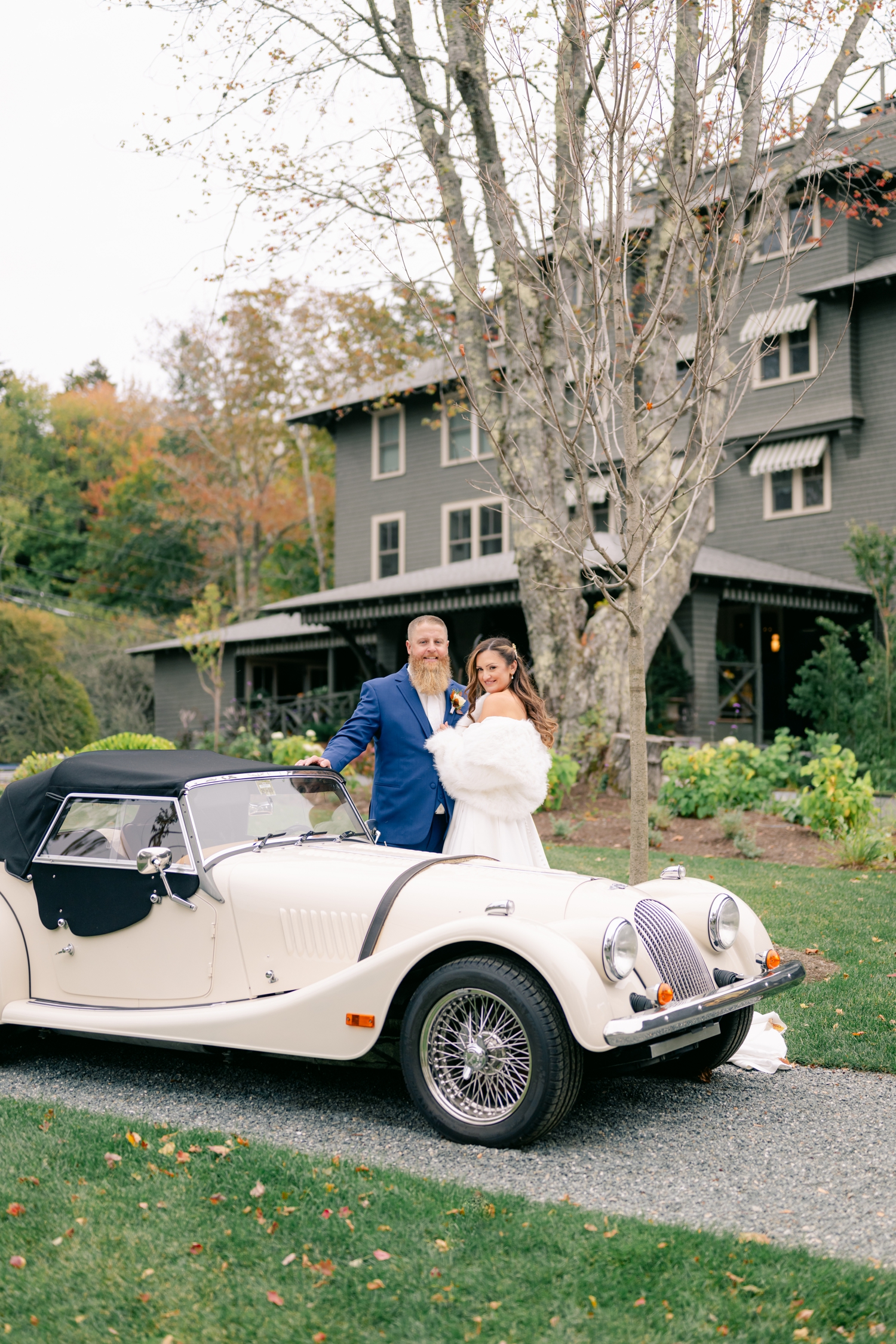 Bride and Groom standing beside a vintage car outside the Asticou Hotel on their autumn elopement day.