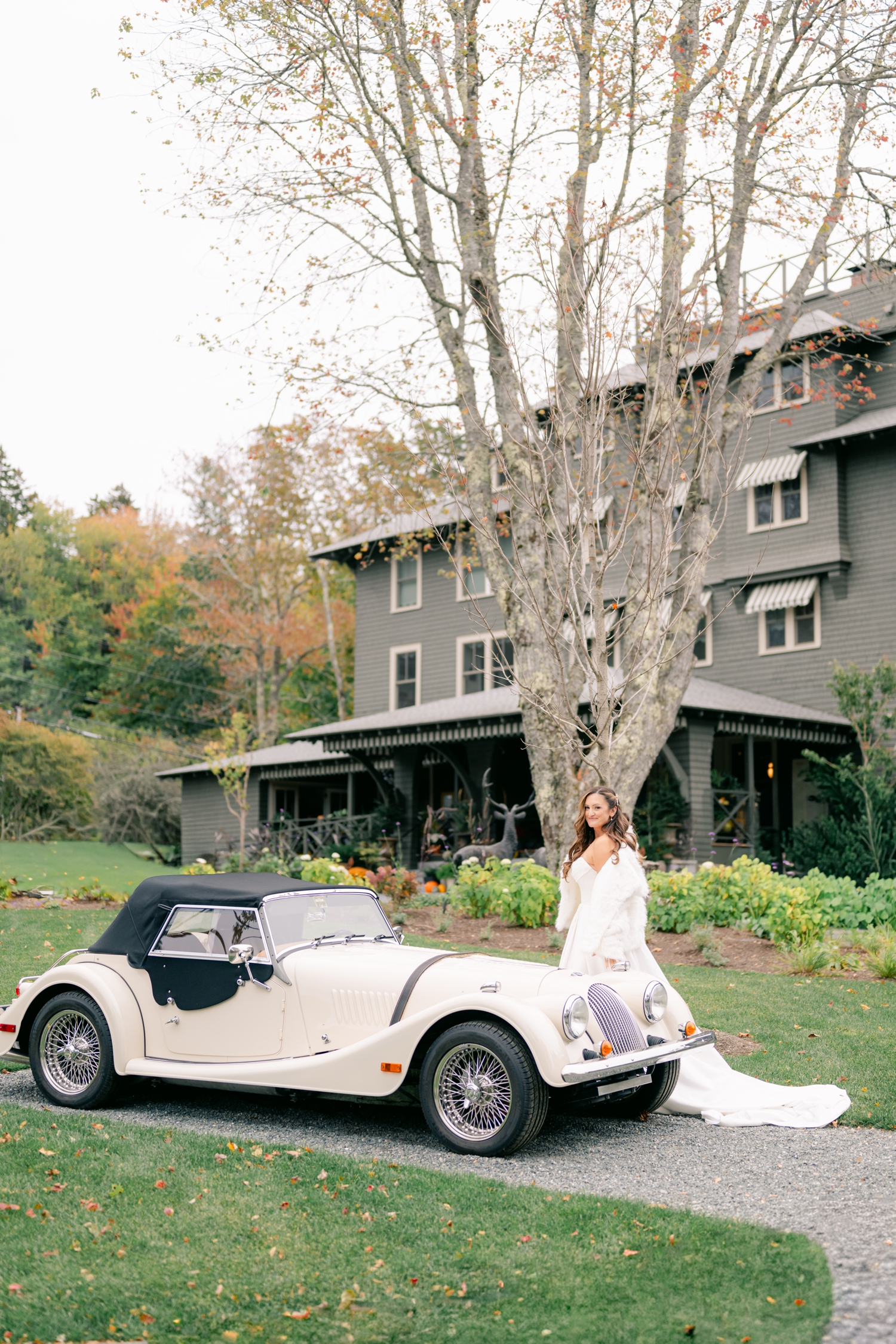 Bride and Groom standing beside a vintage car outside the Asticou Hotel on their autumn elopement day.