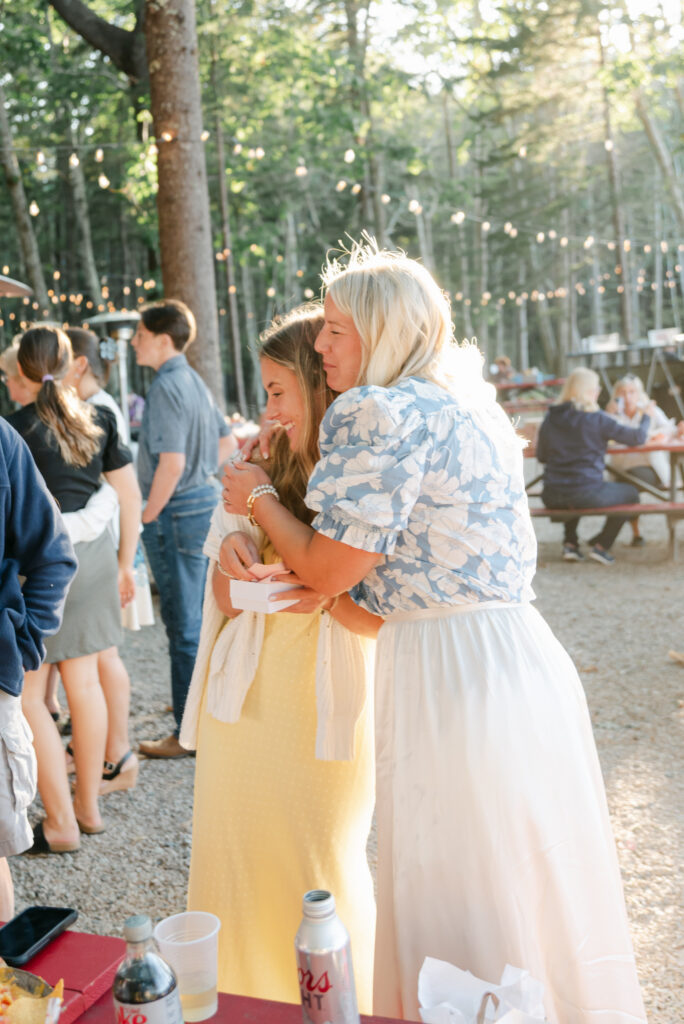 bride embracing guests at an outdoor wedding welcome party in Bar Harbor, Maine