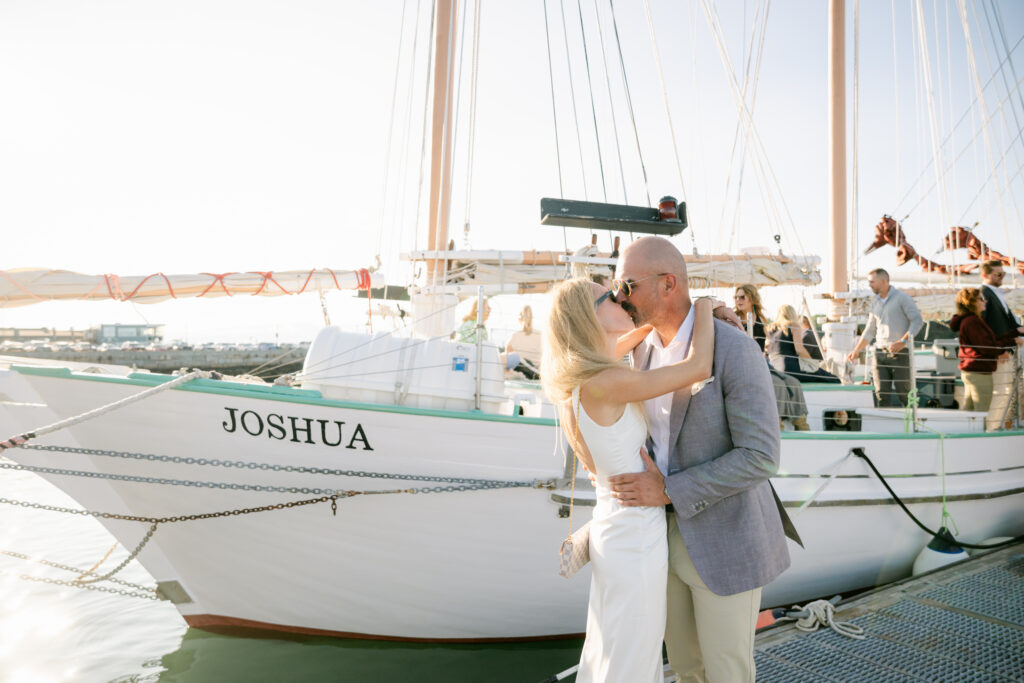 Couple kissing at the dock at their wedding welcome party sail in Bar Harbor Maine photographed by Emily Brianne Photography. 